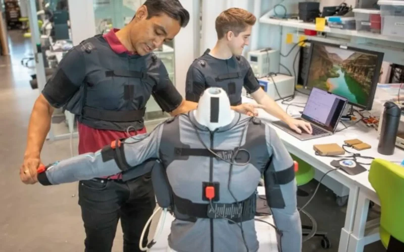 Prabhat Pathak and James Arnold demonstrate the wearable robotic device in the lab. (Harvard)